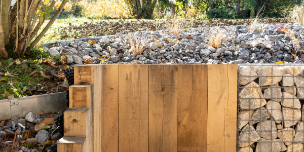 murs-soutenement-bois-gabions-id jardins Mix des matières pour un mur de soutènement en bois et gabions avec un paillage minéral